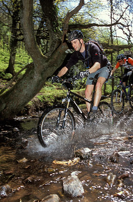 Mountain bike guide splashing through water